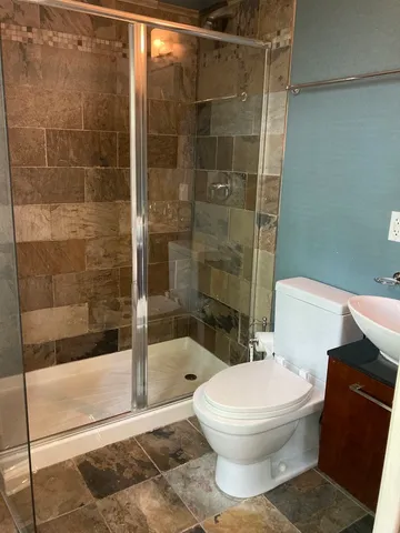 a white toilet sitting next to a bath tub and a shower