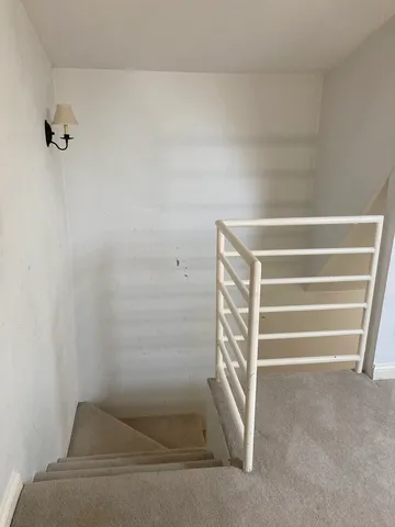 a view of staircase with white walls