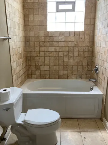 a bathroom with a white bath tub a toilet and a sink