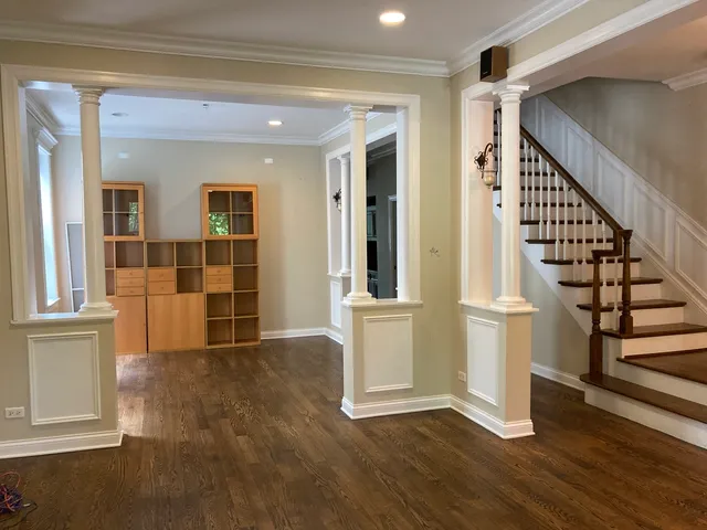 wooden floor in an empty room with windows and pillars in it
