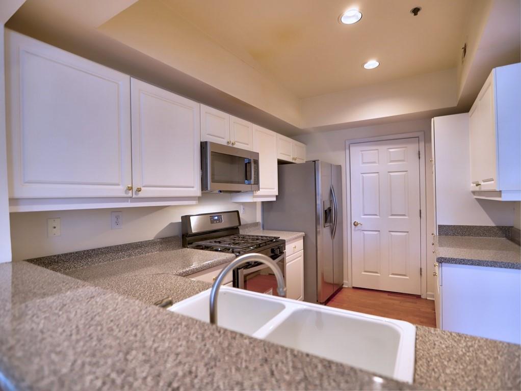 3636 Habersham Road Northwest, Unit 2308 Atlanta, GA 30305 - Photo 13 of 43 a kitchen with stainless steel appliances granite countertop a sink stove and refrigerator