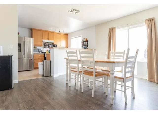 a dining room dining table chairs and refrigerator