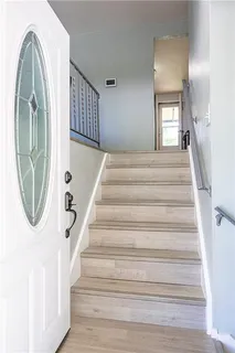 a view of a hallway with wooden floor and entryway