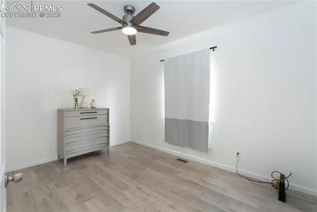 a view of an empty room and window ceiling fan