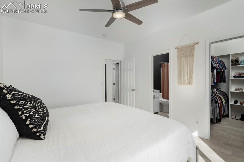 827 Circle Road Palmer Lake, CO 80133 - Photo 14 of 28 a bedroom with a bed and a chandelier