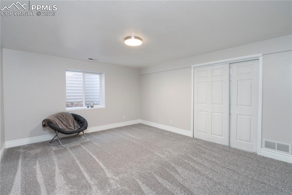 827 Circle Road Palmer Lake, CO 80133 - Photo 15 of 28 a bedroom with a bed and a chair
