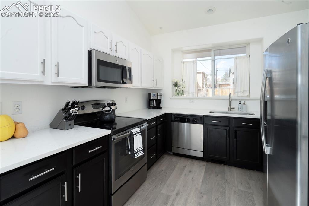 827 Circle Road Palmer Lake, CO 80133 - Photo 9 of 28 a kitchen with a sink stove and microwave
