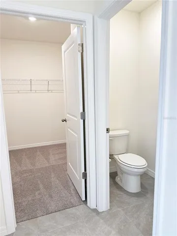 an empty room with a chandelier fan and windows