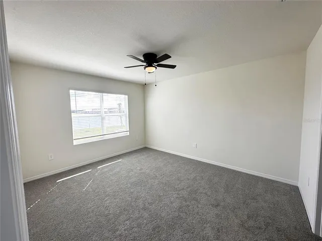an empty room with a ceiling fan and a ceiling fan