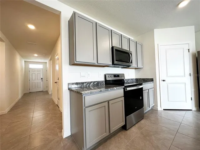 a kitchen with stainless steel appliances granite countertop a sink a stove and a microwave