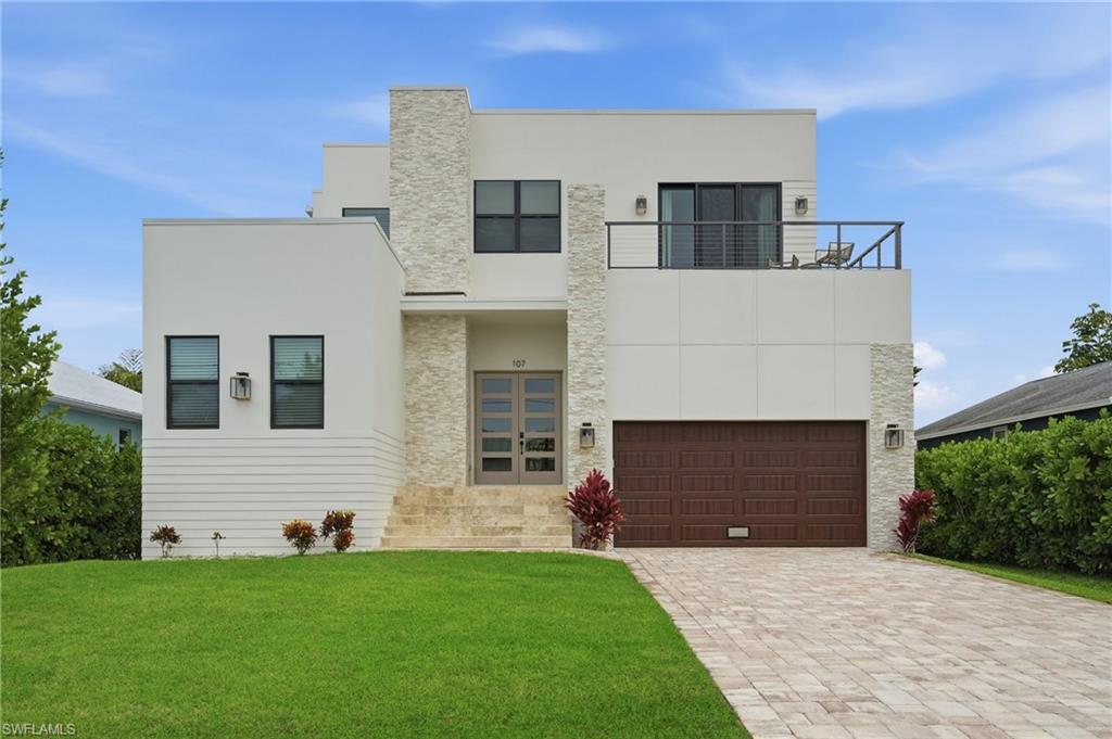 107 West Hilo Street Naples, FL 34113 - Photo 30 of 33 a front view of a house with a garden and yard