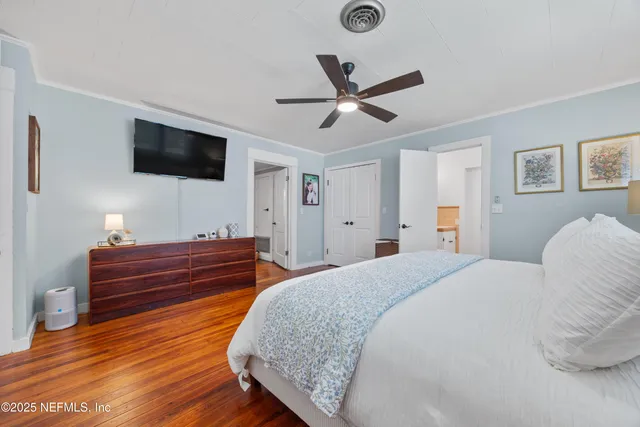 a spacious bedroom with a bed and a flat screen tv