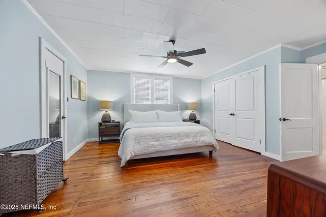 a bedroom with a bed and wooden floor