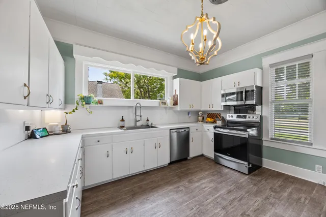a kitchen with stainless steel appliances granite countertop a stove sink and cabinets