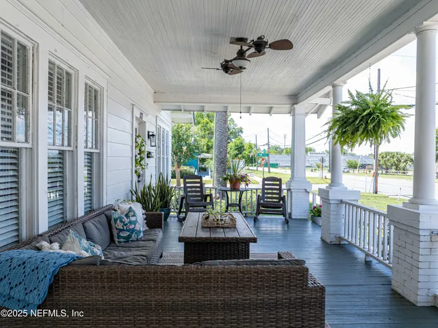 a living room with furniture large window and wooden floor
