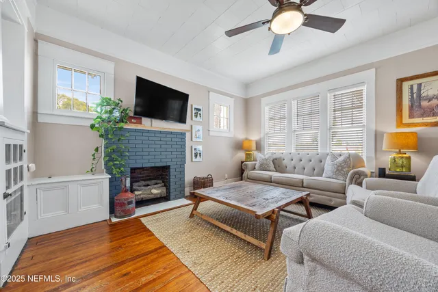 a living room with furniture a fireplace and a flat screen tv