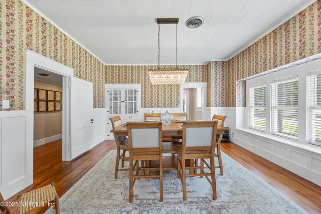 a dining room with furniture a chandelier and wooden floor