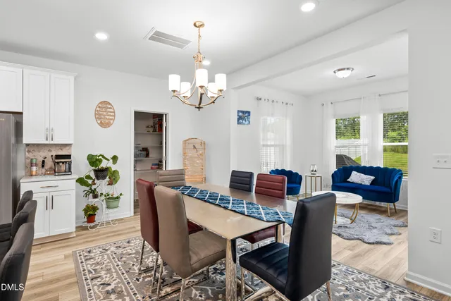 a view of a dining room with furniture a rug and wooden floor