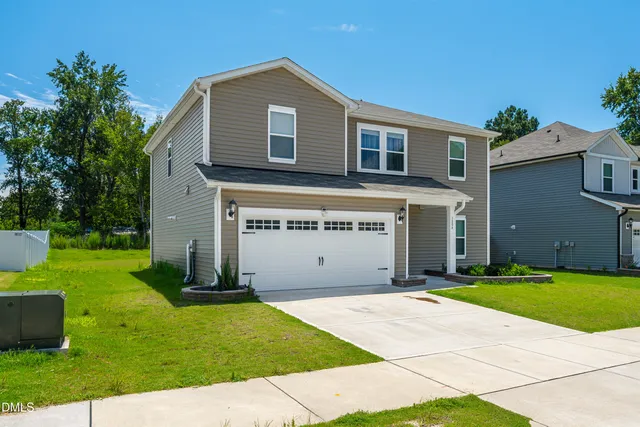 a front view of a house with a garden and yard