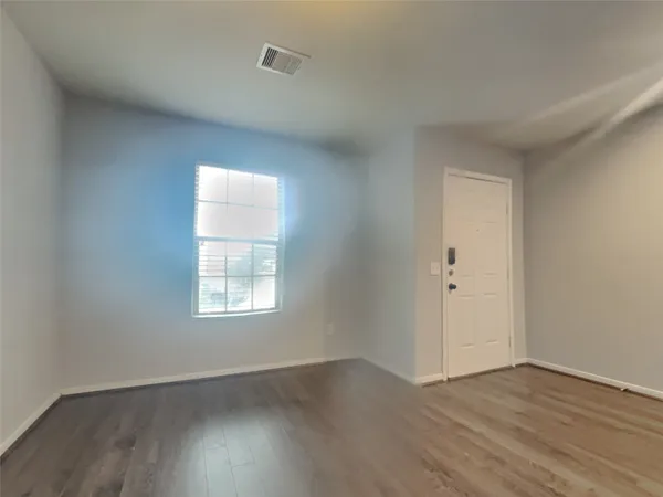 an empty room with wooden floor and window