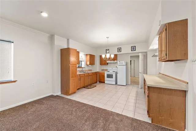 a view of a kitchen with a sink and chandelier