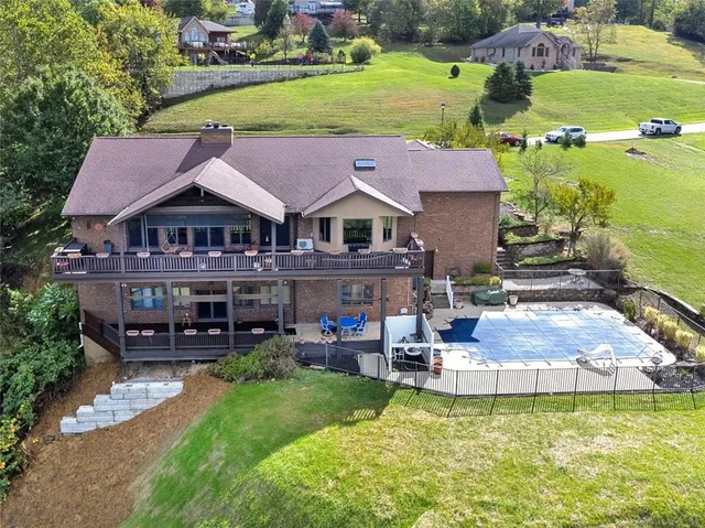 an aerial view of a house with swimming pool garden and patio