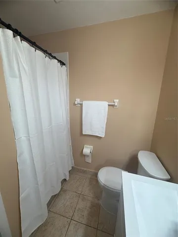 a bathroom with a toilet and a shower curtain