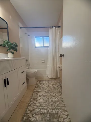 a bathroom with a sink a toilet a window and vanity
