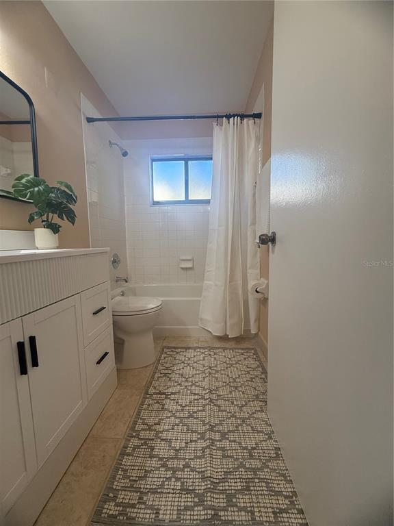 11707 Raintree Village Boulevard, Unit C Temple Terrace, FL 33617 - Photo 21 of 31 a bathroom with a sink a toilet a window and vanity