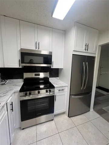 a kitchen with cabinets and steel stainless steel appliances