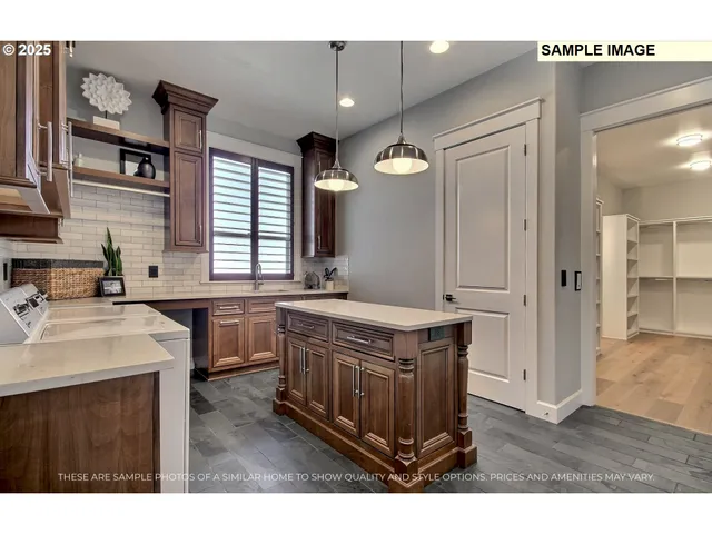 a kitchen with stainless steel appliances granite countertop a sink a stove a refrigerator and island