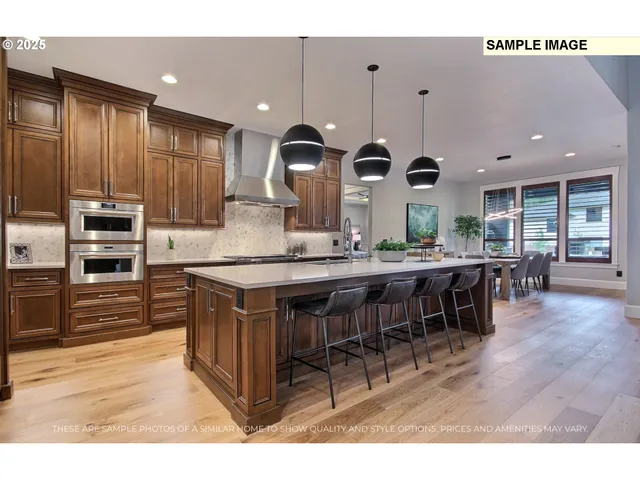 a kitchen with stainless steel appliances kitchen island granite countertop a table chairs and a refrigerator
