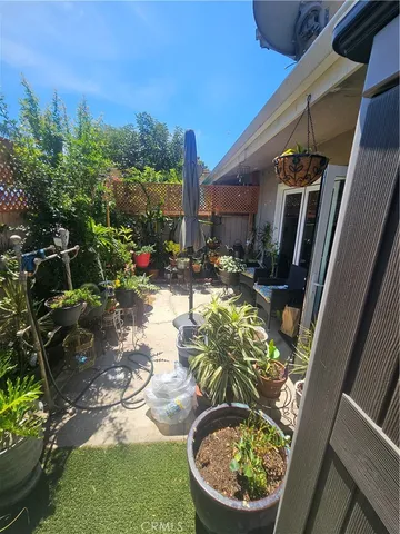 a view of patio with couches table and chairs with potted plants