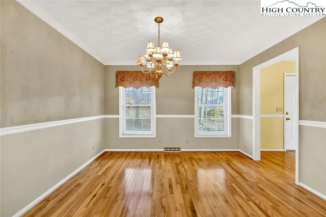 a view of wooden floor in an empty room with a window