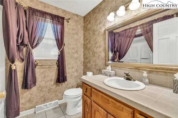 a bathroom with a sink a toilet and a mirror