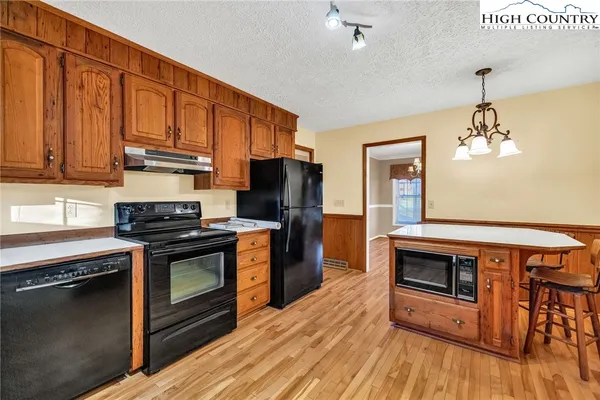 a kitchen with granite countertop wooden floors and stainless steel appliances