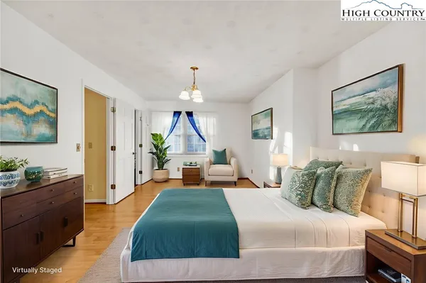 a bedroom with a bed and a chandelier