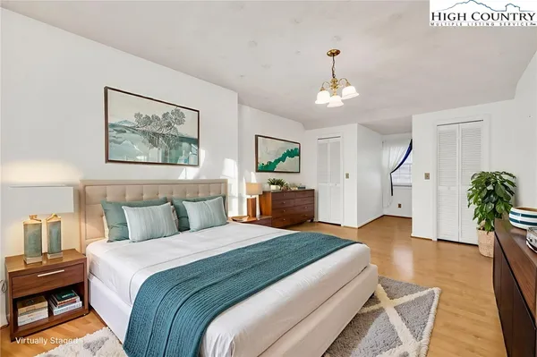 a bedroom with a large bed and a chandelier