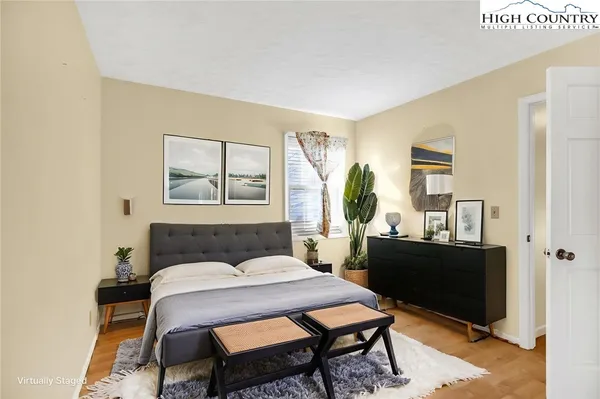 a bedroom with a bed and wooden floor