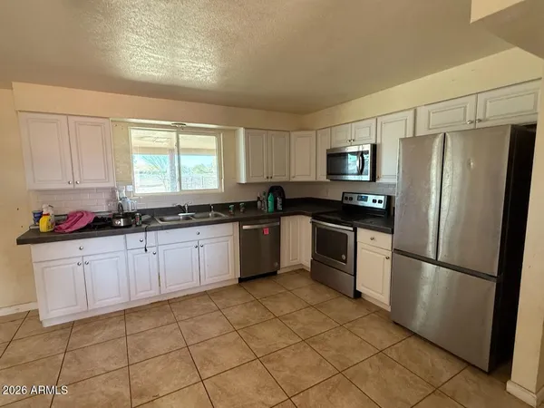 a kitchen with granite countertop a refrigerator and a sink