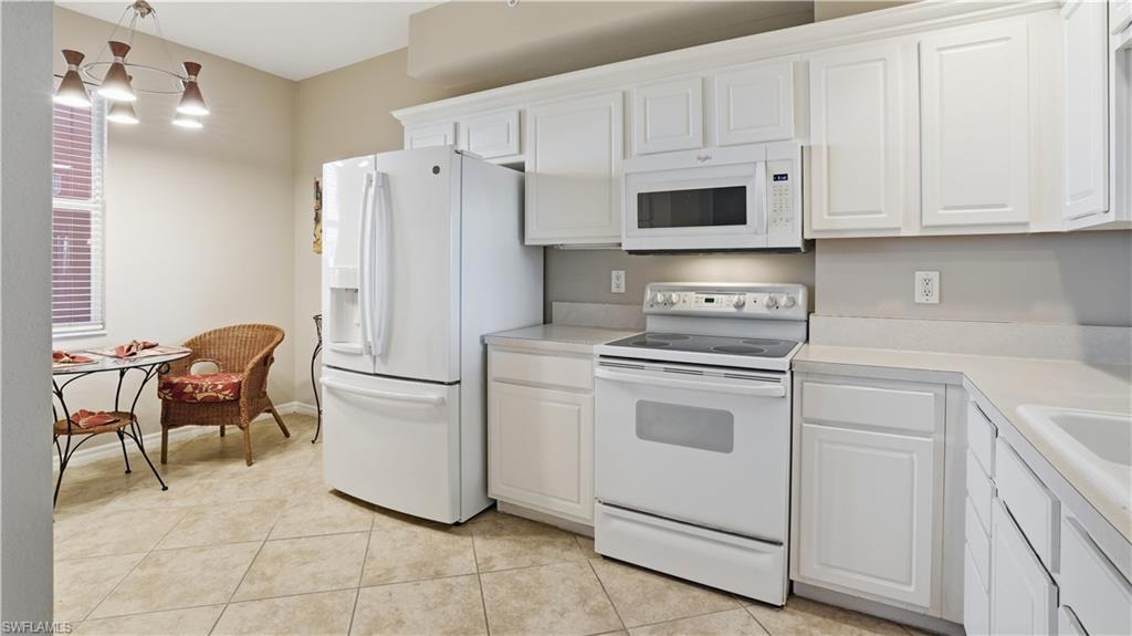 150 Lenell Road, Unit 503 Fort Myers Beach, FL 33931 - Photo 18 of 32 a kitchen with stainless steel appliances white cabinets and a stove