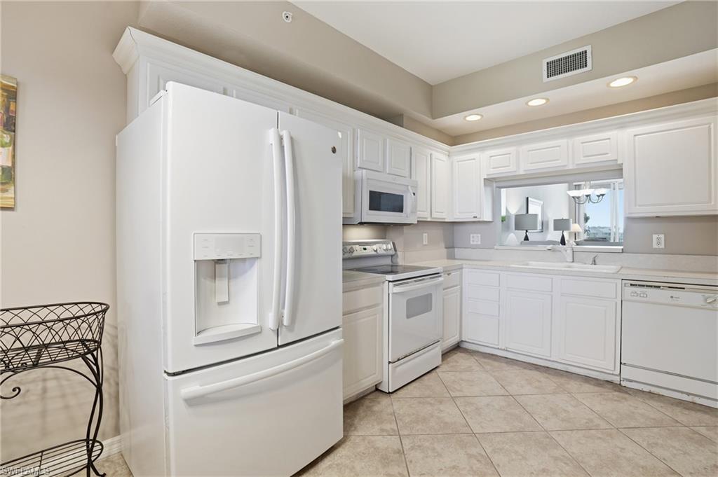 150 Lenell Road, Unit 503 Fort Myers Beach, FL 33931 - Photo 19 of 32 a kitchen with white cabinets and white appliances