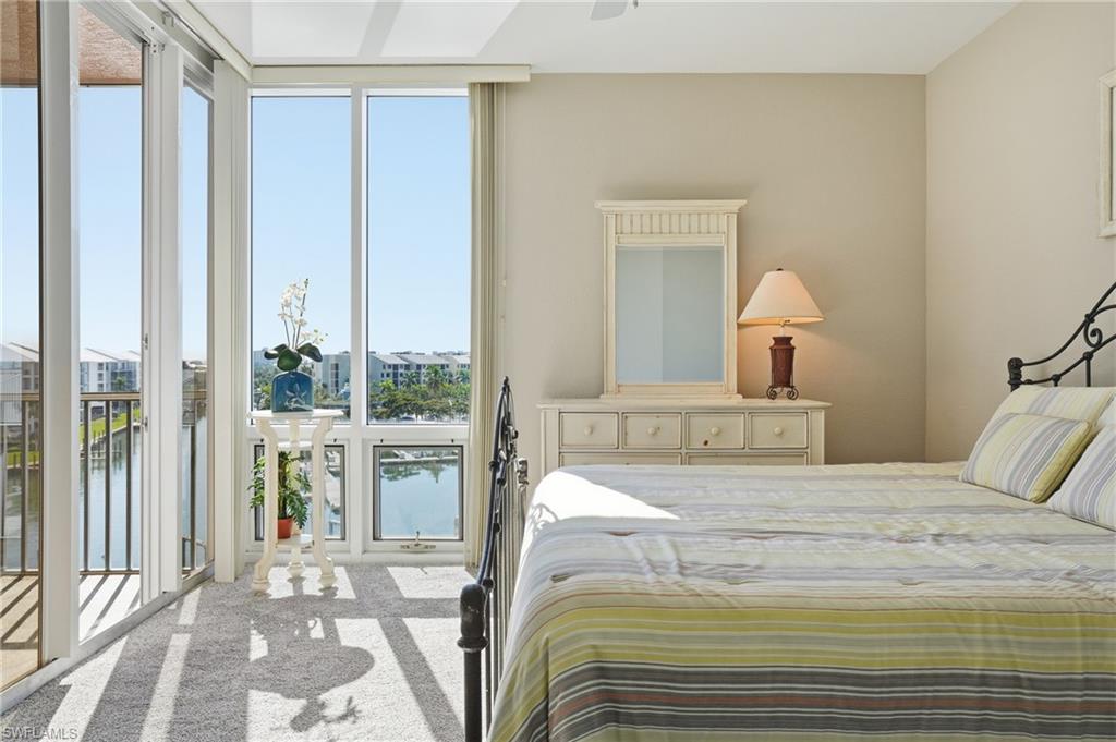 150 Lenell Road, Unit 503 Fort Myers Beach, FL 33931 - Photo 23 of 32 a bedroom with a large bed and a lamp next to a window