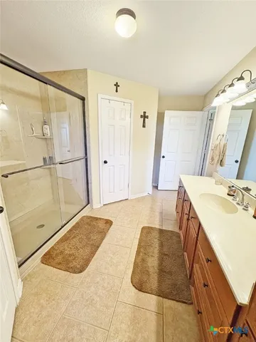 a spacious bathroom with a granite countertop sink a mirror and shower