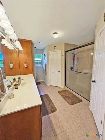 a spacious bathroom with a shower sink and mirror
