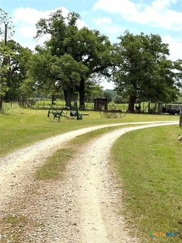 a view of a house with a big yard and large trees