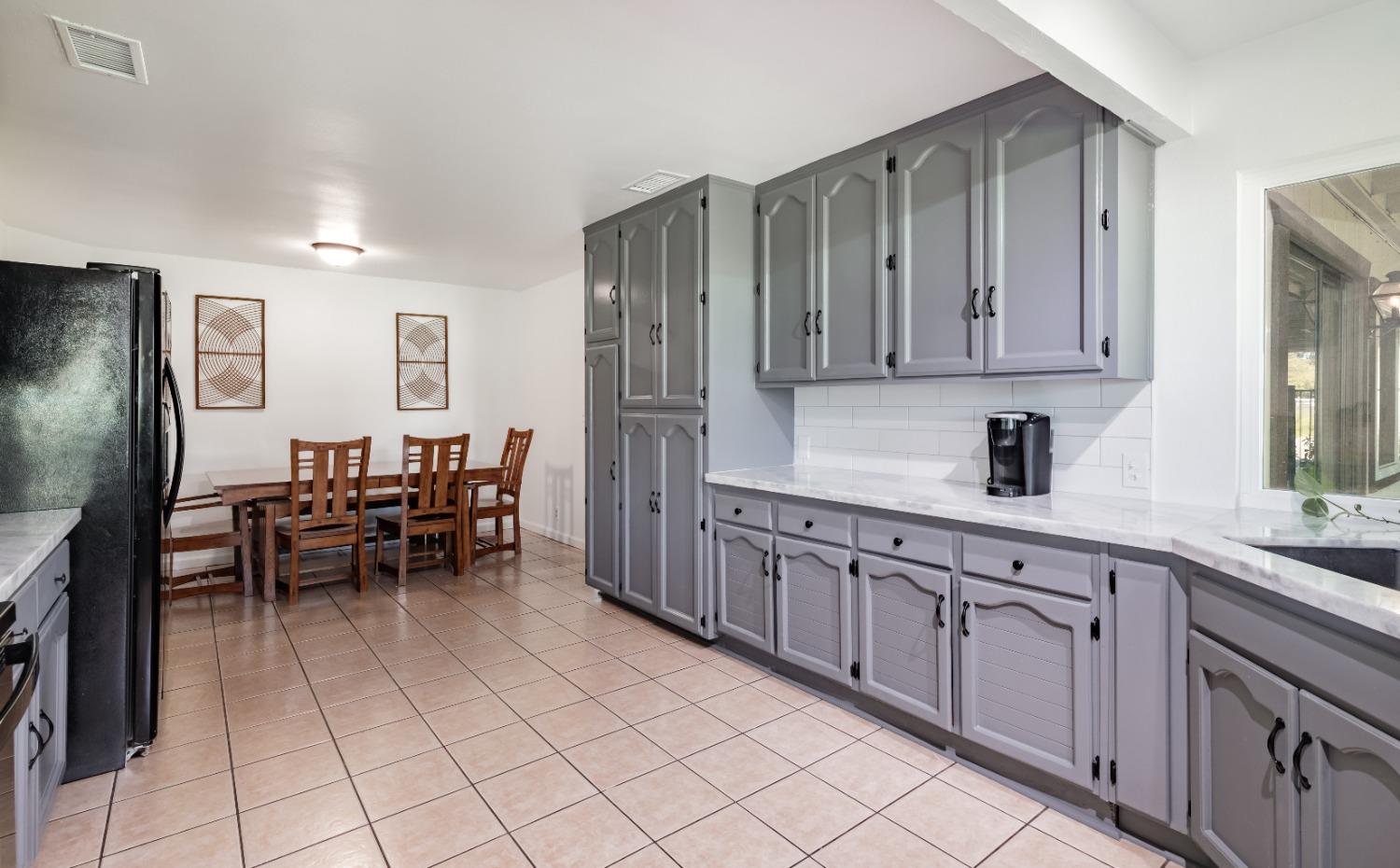 16993 Jennifer Court Madera, CA 93636 - Photo 11 of 55 a kitchen with granite countertop cabinets a sink stainless steel appliances and a window