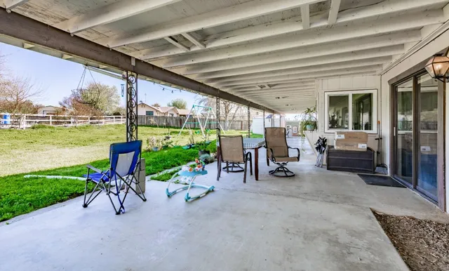 a backyard of a house with table and chairs