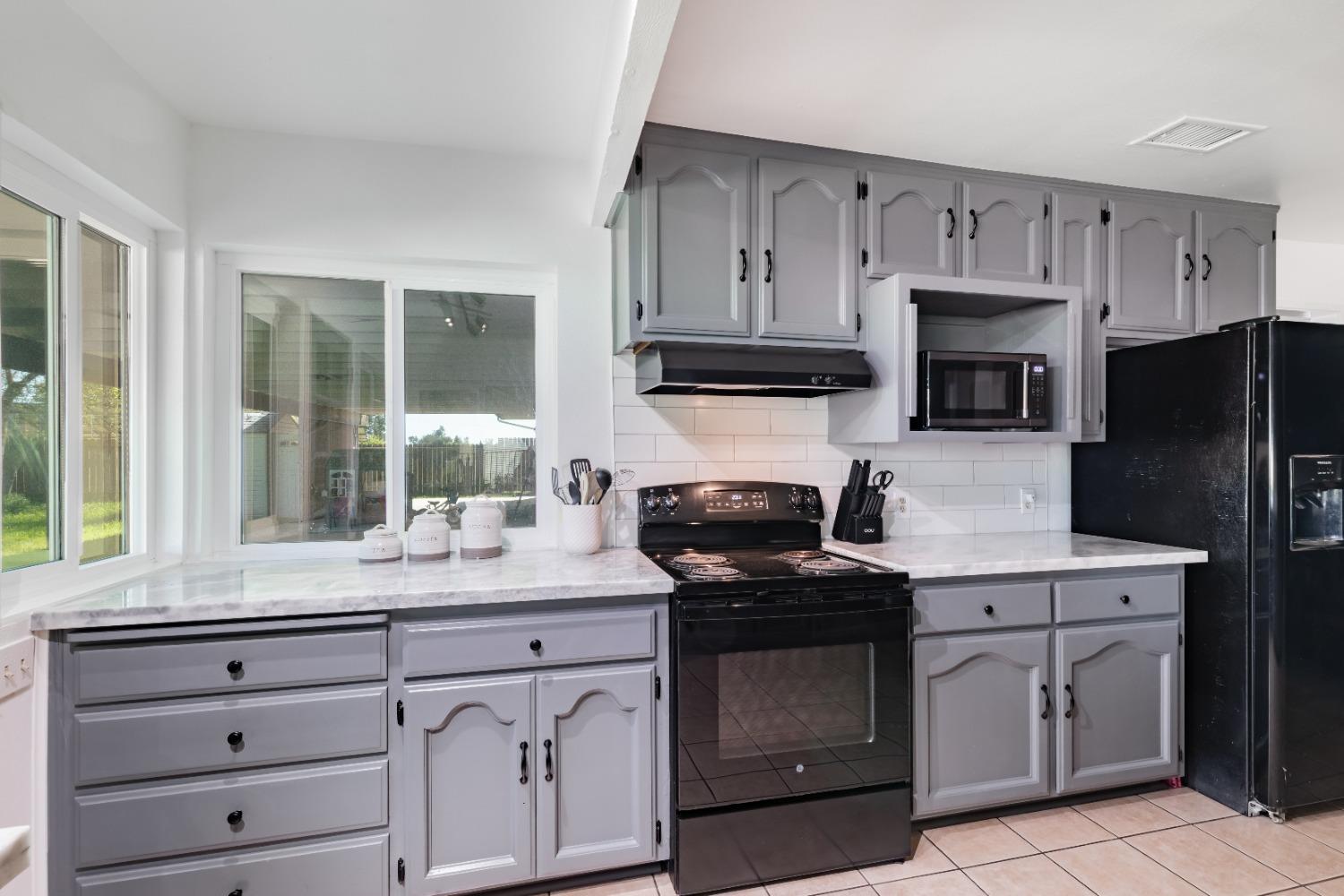 16993 Jennifer Court Madera, CA 93636 - Photo 10 of 55 a kitchen with cabinets stainless steel appliances and a window