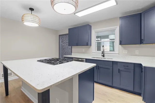 a kitchen with a sink cabinets and wooden floor